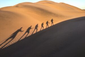 Shadows of people walking over a dessert