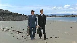 Two men walking at the beach in formal wear